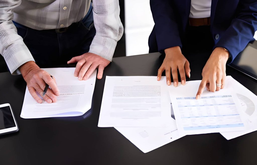 People reviewing shipping documents at a table