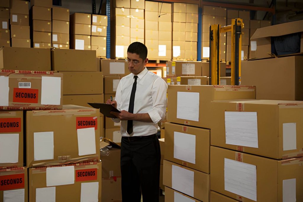 Worker reviewing air freight documentation beside packed cargo